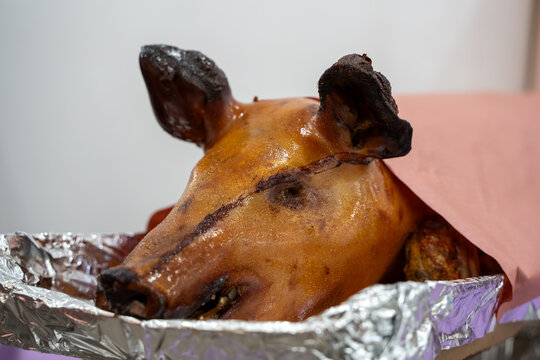 Close up of roasted whole pig head in tray.