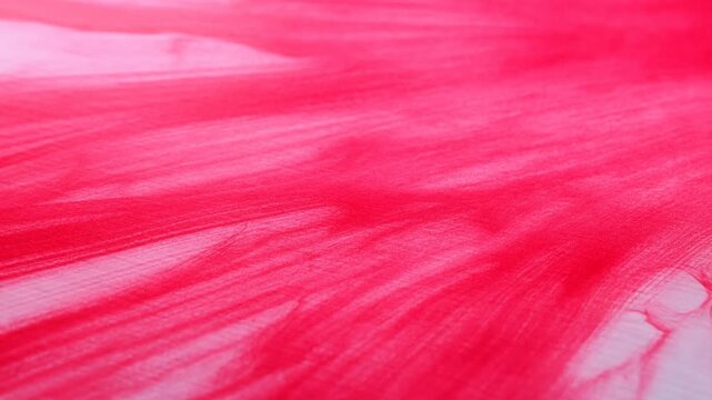 Bright red watercolor pigment bleeding and spreading on wet paper