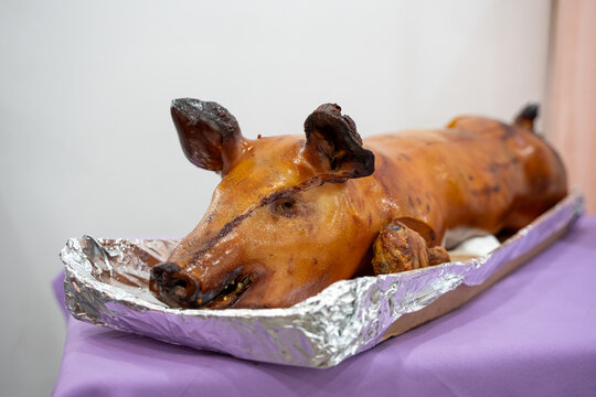 View of roasted whole pig served in foil tray.