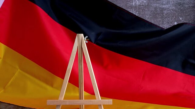 Letter board with message MADE IN GERMANY National symbol. German wave silky flag background. Concept of pride product quality standard and reliability 