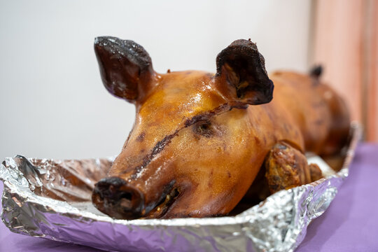 View of roasted whole pig served in foil tray.