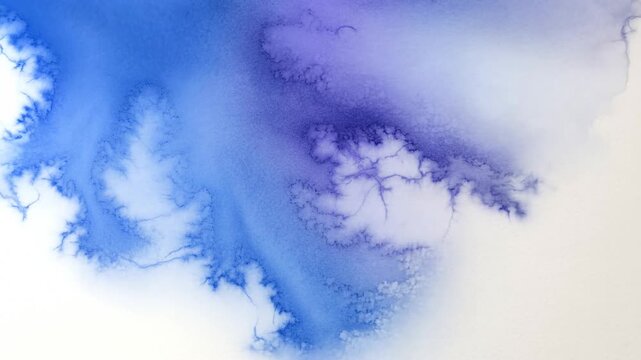 Blue watercolor pigment bleeding and spreading on wet paper