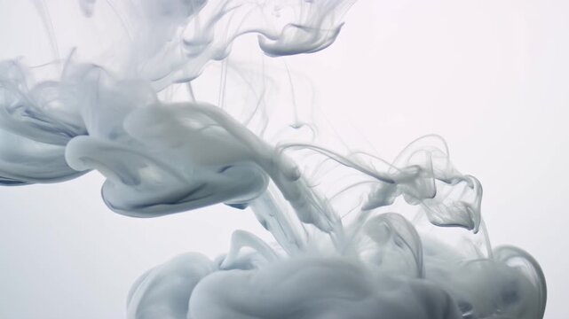Grey ink swirling and diffusing in clear water