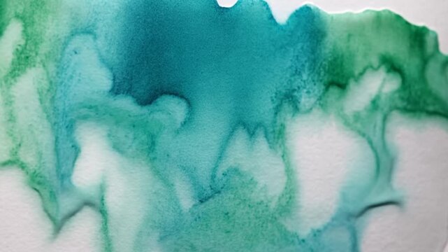 Green watercolor pigment bleeding and spreading on wet paper