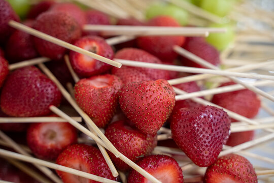Close up of fresh strawberries with wooden skewers.