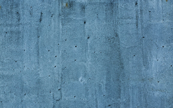 Close-up of a textured blue concrete wall, featuring various imperfections and nuances typical of cement surfaces, perfect for backgrounds and designs.