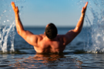 Fototapeta premium Water splashes around muscular swimming man. Active water motion shows fitness endurance. Fresh water droplets highlight athletic body. Ocean water activity boosts wellness vitality.