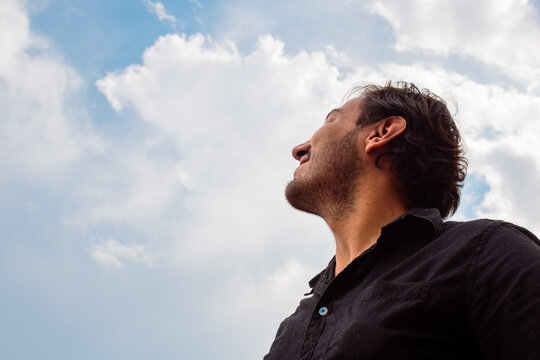 Smiling young man looking up at the sky