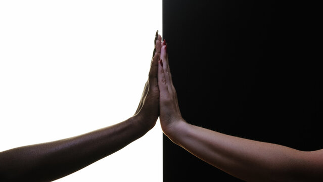Diversity tolerance. Equality support. Silhouette of female hands touching palms together isolated on black white copy space background.