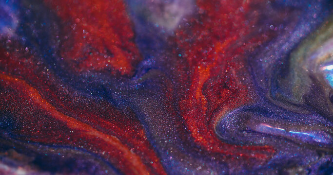 Sparkling ink. Paint stream. Purple liquid pigment swirl lava texture with red glitter mix color blur flare art abstract background.