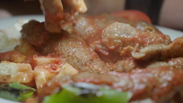 Close-up of Fork Picking Up Piece of Turkish Iskender Kebab