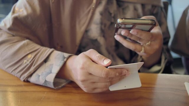 A person is using a mobile phone to scan the QR code for the menu in a cafe