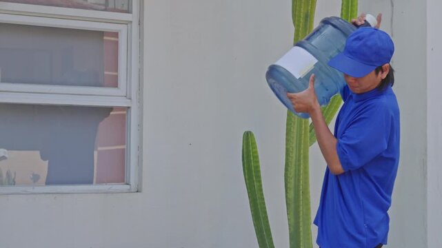Delivery service worker lifting aplastic water container to carry away