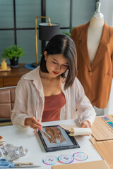 Asian woman designer using tablet design cloth © Wanda