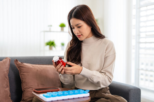 Wellness Routine.Woman holding supplement bottle and considering  a bottle lable .
