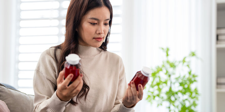 Wellness Routine.Woman holding supplement bottle and considering  a bottle lable .