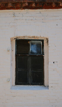 An old window of an old house. Against the background of white walls.