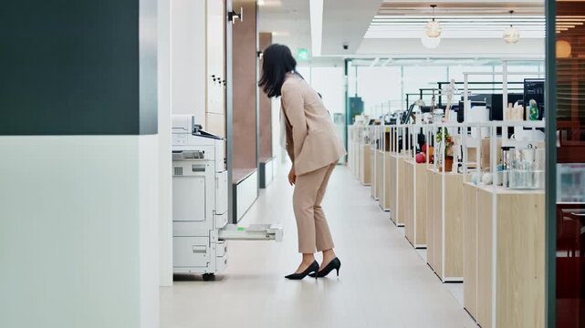Young Asian Businesswoman Refilling Paper in Office Printer, Workplace Productivity Concept