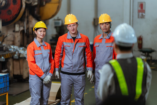 Team discusses safety measures in a factory during a work meeting