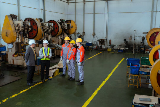 Team discusses safety measures in a factory during a work meeting