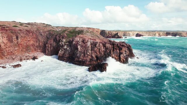 Dynamic aerial video footage capturing powerful ocean waves crashing against rugged cliffs with dramatic force.