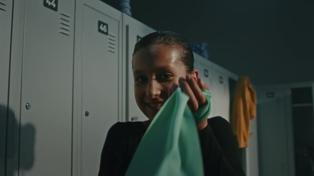 Teenage Female Gymnast Dancing Funnily inside Bright Sports Changing Room. Girl Genuine Positive Emotions, Carefree Mood, and Expressive Movements. Concept of Youth Lifestyle and Modern Culture.