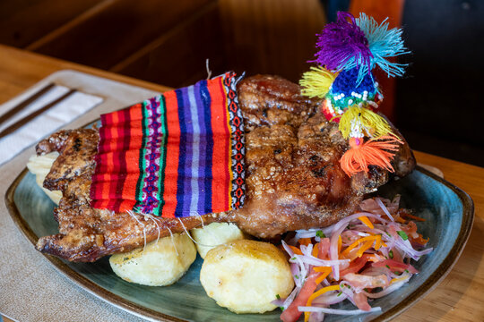 raditional Peruvian dish of whole roasted guinea pig (cuy) served on a plate in a restaurant in Cusco. Authentic Andean cuisine showcasing cultural heritage and local gastronomy in Peru.