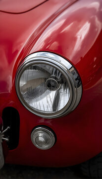 Close-up of Vintage Red Car Headlight and Front Panel