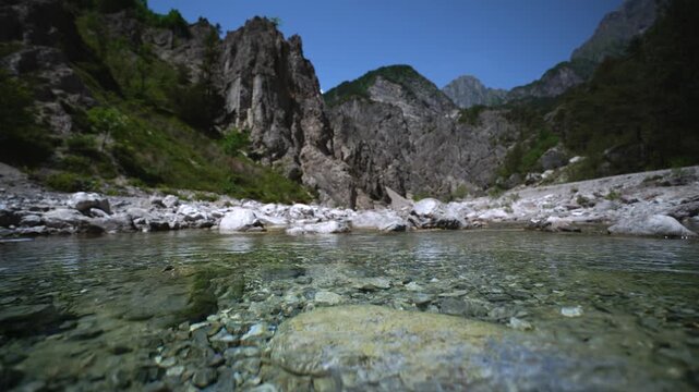 Transparent alpine mountain stream water rushing over pebbles, Friulian Dolomites, Northern Italy.