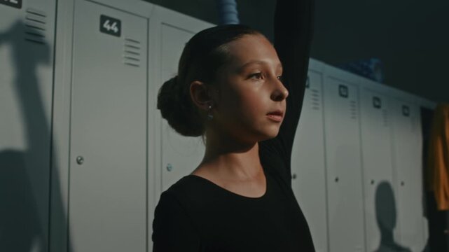 Focused Young Gymnast Prepares Before Training Session, Using Resistance Band Near Lockers to Activate Core Muscles, Warm Up Shoulders. Athlete Follows Professional Mobility Routine for Flexibility.