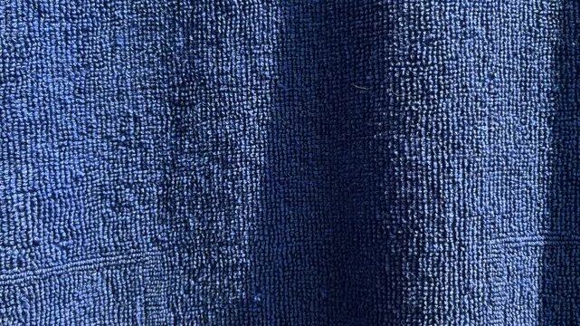 Close up view of dark blue shower towel texture. Fluffy carpet background. Blank bathroom textile. Warm sweater natural material. Fabric backdrop detail. Blue flat surface. Home canvas design. space
