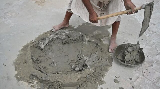 Construction Worker Mixing Fresh Cement Mortar by Hand with Shovel for Masonry and Plastering Work &ndash; 4K Footage