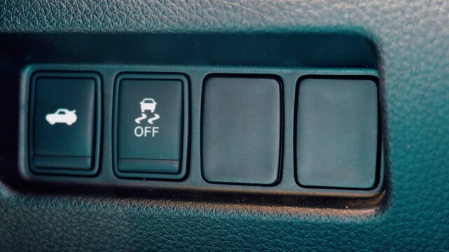 Traction control off and trunk release buttons on car dashboard