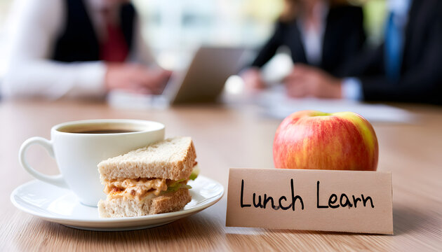 Meeting with coffee and an apple sandwich scheduled for the team. The note indicates it's a Lunch Learn. Background shows blurred images of business people collaborating. Corporate training session in