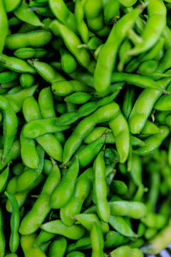 Full frame of fresh green edamame pods, Yuagari Musume variety, packed with vibrant color.