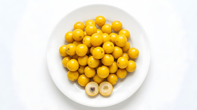 Heap of fresh ripe yellow nance fruit arranged on a white plate with isolated, tropical