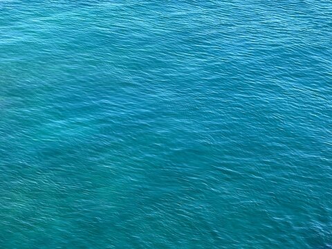 Blue calm sea water surface aqua background.