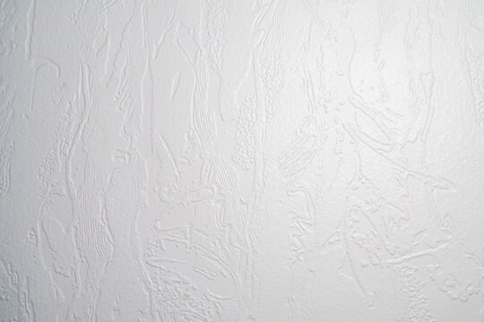 Textured white wall surface with subtle patterns and details, perfect for backgrounds and design projects.