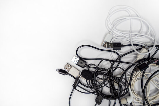 tangled cables and wires on a white background, showcasing various types of connection cables for electronics and accessories.