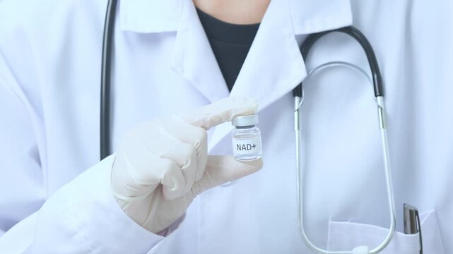 Confident professional doctor holding glass vial representing advanced nad+ therapy medical treatment inside clinical hospital laboratory room