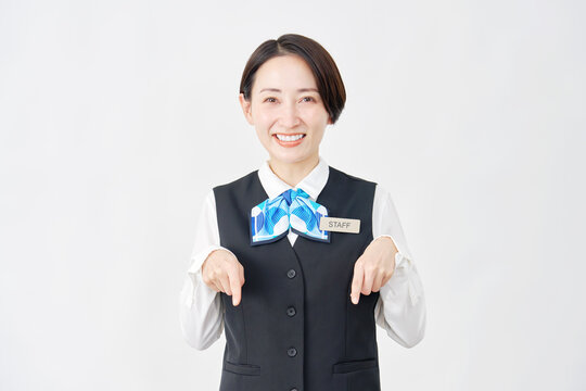 下を指差す女性スタッフ　受付嬢・銀行員　白背景