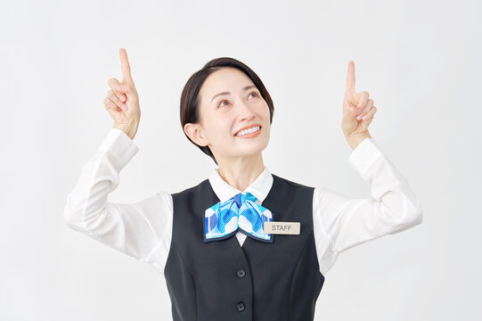 上を指差す女性スタッフ　受付嬢・銀行員　白背景