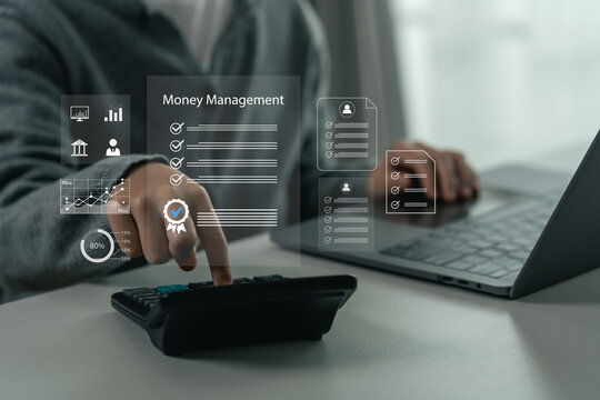 Person using calculator for financial calculation with transparent digital interface icons displaying money management concepts and data analytics on desk with laptop computer