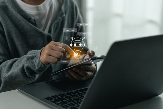 Close-up of person using digital tablet with artificial intelligence chatbot icon hologram above finger interaction on laptop computer in modern indoor workspace environment