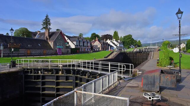 Eine Schleuse zwischen traditionellen Geb&auml;uden unter einem blauen Himmel, Kaledonischer Kanal, Fort Augustus, Loch Ness, Schottland, Vereinigtes K&ouml;nigreich, Gro&szlig;britannien 