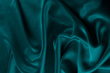 Deep teal fabric texture with soft folds © reddish