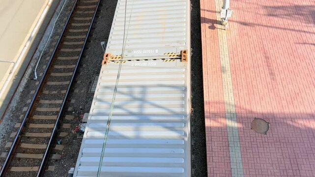 Aerial view of freight train wagon passing platform at railway station