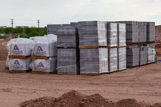 Palletized building materials stored at a construction staging site, illustrating material supply, logistics, site preparation, building development, and construction operations