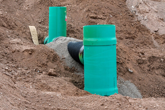 Underground stormwater drainage pipes under installation at a commercial development site, representing utility infrastructure, water runoff management, and civil engineering construction