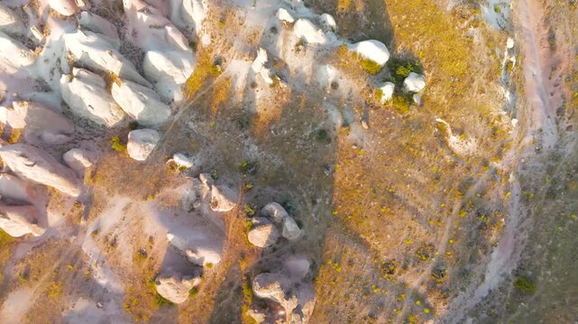 Goreme, Nevsehir, Turkey. Devrent Valley's eroded volcanic tuff formations, a sweeping aerial view over the sculptural ridges and fairy chimneys at golden hour. Aerial View, MasterShots, Tilt up, Zoo